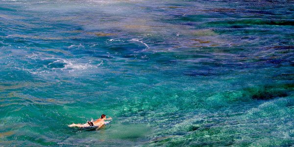 Man lying on surfboard in the ocean